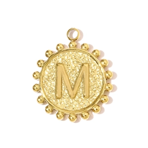 Macro shot of 18K gold plated round pendant featuring relief letter M and hammered texture