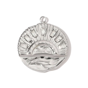 Macro detail of a silver sunburst pendant with sparkling clear zircon stones on white background