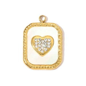 Detailed close-up of golden heart pendant with white shell inlay and sparkling crystals