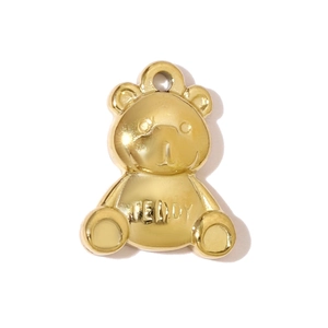 Dettaglio ravvicinato di un ciondolo a forma di orsetto dorato con incisione Teddy e finitura
