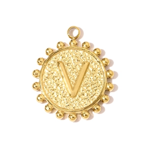 Macro detail of a gold square letter V pendant with hammered texture and beaded edge