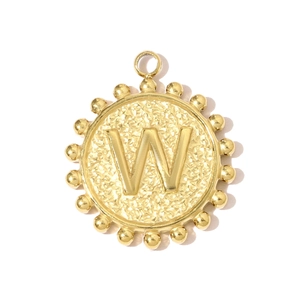 Detail of a gold square letter W pendant with hammered texture and beaded sunburst edges