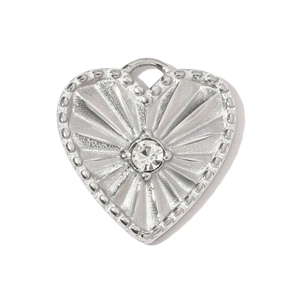Macro detail of silver heart pendant with sunburst texture and sparkling center crystal