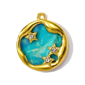 Vue détaillée d'un pendentif rond doré avec motif nébuleuse bleue et petites étoiles
