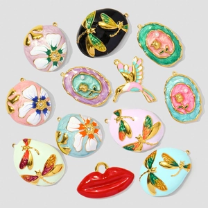 Detailed assortment of enamel charms featuring flowers, dragonflies, and birds in gold finish
