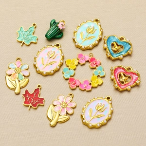 Detailed flat lay of golden stainless steel enamel charms for DIY jewelry making