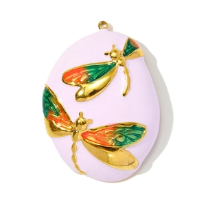Macro detail of egg-shaped enamel pendant featuring colorful dragonfly and floral motifs