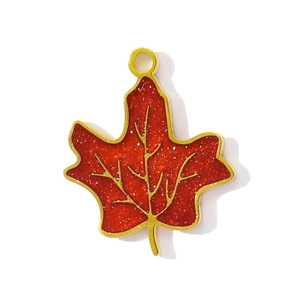Macro detail of red maple leaf pendant with golden edges and sparkling drip oil finish