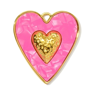 Detail of a pink resin heart pendant with gold metal edges and a textured inner heart