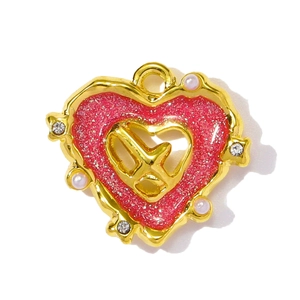 Detailed view of heart-shaped gold pendant with pink enamel, pearls and crystals