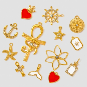 Macro shot of assorted gold-plated stainless steel charms with enamel and rhinestones