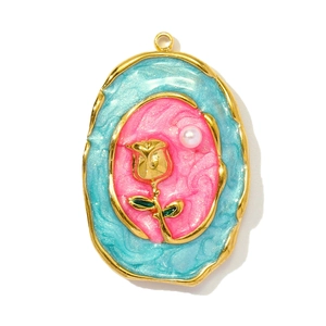 Macro shot of oval vintage rose pendant with pink marble enamel and pearl detail