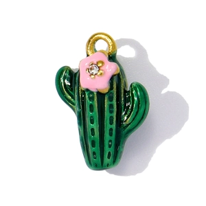 Macro view of green enamel cactus pendant with pink flower and sparkling white crystal