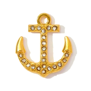 Detail of a gold anchor pendant encrusted with white crystals for jewelry making