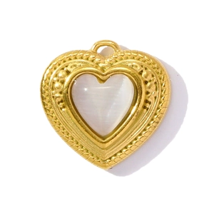 Detailed macro view of heart-shaped gold pendant with white gemstone and woven texture