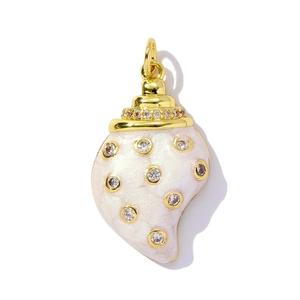 Macro detail of gold-plated shell pendant with white pearlescent enamel and zircon stones