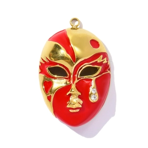 Détail d'un pendentif masque de théâtre avec émail rouge, finition dorée et strass