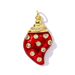 Macro shot of red enamel strawberry pendant with sparkling zircon insets and gold plating