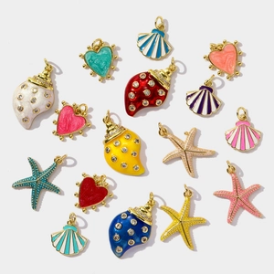 Detailed view of colorful enamel starfish, shell, and heart charms with gold plating