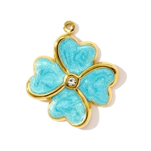 Detalle de colgante de trébol dorado con purpurina azul y cristal central brillante
