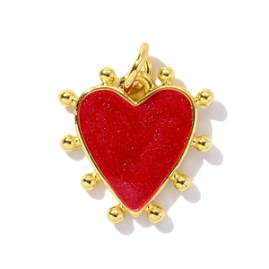 Detail of red glitter heart pendant with gold bead border for jewelry making