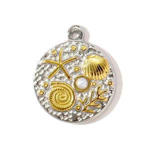 Détail macro d'un pendentif océan bicolore en acier avec motifs de coquillages et perle