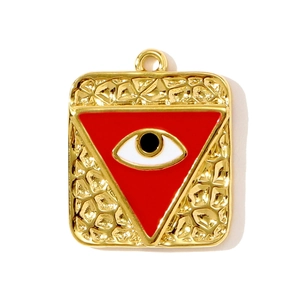 Detalle de colgante cuadrado dorado con ojo de esmalte rojo y textura de metal martillado