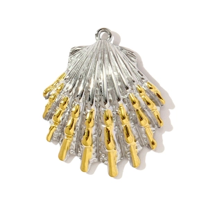 Détail macro du pendentif coquillage bicolore avec touches dorées et rainures argentées