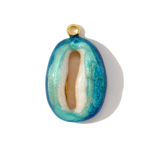 Detailed macro view of an oval resin pendant with blue and green swirls and gold ring