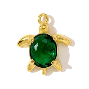 Detail of a golden sea turtle pendant with a large green faceted emerald-cut resin stone