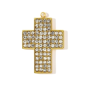 Gros plan d'un pendentif croix en acier inoxydable doré avec strass blancs micro-pavés