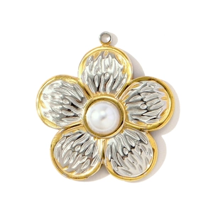 Détail d'un pendentif fleur bicolore avec pétales argentés et incrustation de perle centrale