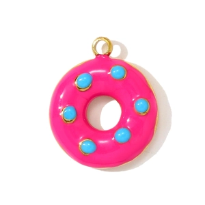 Detail eines rosa Donut-Anhängers mit blauen Punkten und goldenem Edelstahl-Finish