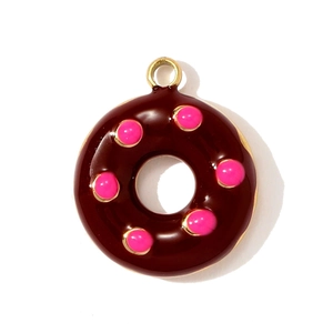 Makroaufnahme eines schokoladenbraunen Donut-Anhängers mit rosa Perlen und Goldring