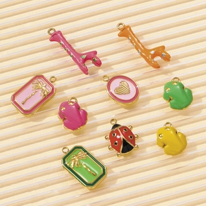Detailed view of colorful enamel animal and heart pendants for DIY jewelry making