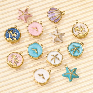 Detalle de dijes de esmalte de estrella de mar y palmera para creación de joyas de playa