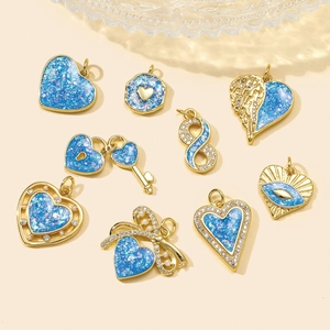 Detailed set of nine gold-plated blue opal charms featuring heart, key and angel wing designs