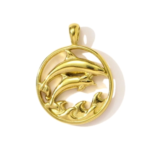 Detailed close-up of a hollow round gold dolphin pendant featuring ocean waves and two dolphins