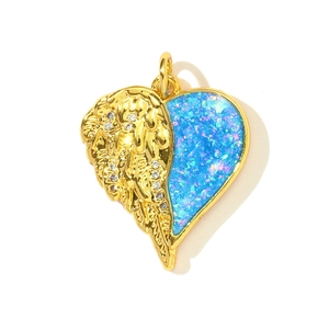 Macro detail of copper heart pendant with blue opal effect wing and sparkling zircons