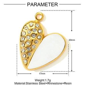 Detail of heart pendant with white resin, rhinestones and golden stainless steel finish
