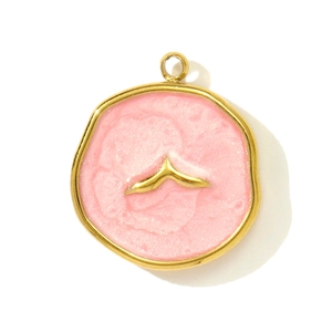 Detalle de un colgante irregular de esmalte rosa dorado con incrustación de cola de ballena