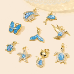 Pendentifs animaux dorés avec opale bleue et cristaux, incluant papillon et tortue marine