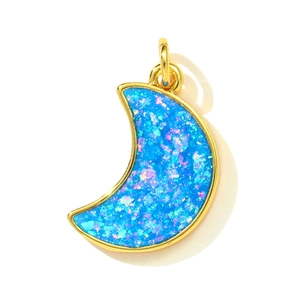 Detailed view of crescent moon pendant with blue fire opal inlay and golden edges
