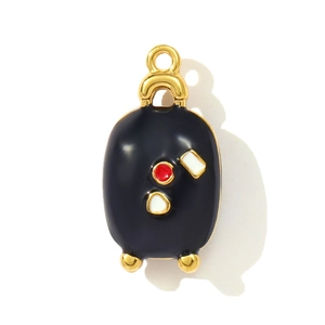 Detailed view of suitcase pendant in black enamel with gold trim and red dot accents