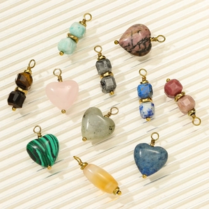 Macro detail of natural stone heart and prism pendants with gold wire wrapping