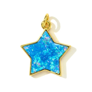 Macro shot of gold star pendant with bright blue opal inlay and polished metal edges