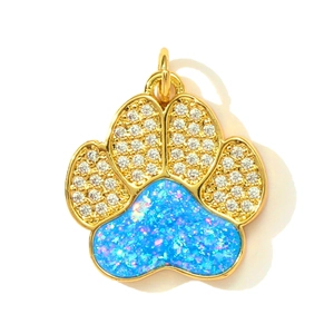 Golden paw-shaped pendant featuring blue opal inlay and sparkling white cubic zirconia