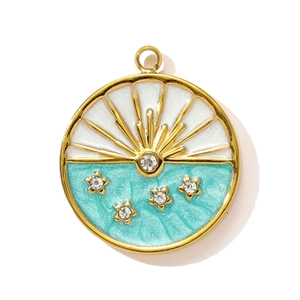 Detailed macro view of a sun and star enamel pendant with golden finish and clear crystals