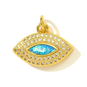 Détail macro du pendentif œil protecteur doré avec opale bleue et sertis de zircons