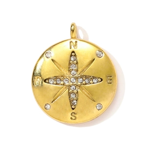 Vue détaillée d'un pendentif boussole doré orné d'étoiles et de zircons brillants